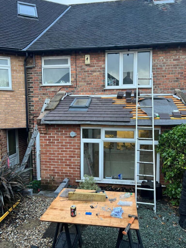 This is a photo of a roof extension that is having new roof tiles installed. This is a photo taken from the roof ridge looking down a tiled pitched roof on to a flat roof. Works carried out by Wingerworth Roofing Repairs