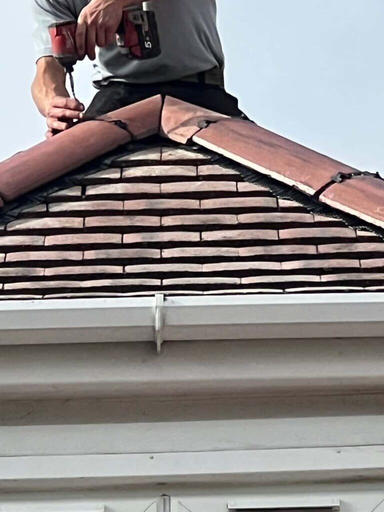 This is a photo of one of the operatives of Wingerworth Roofing Repairs installing new ridge tiles